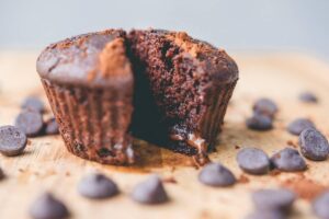 un muffin al cioccolato circondato da gocce di cioccolato