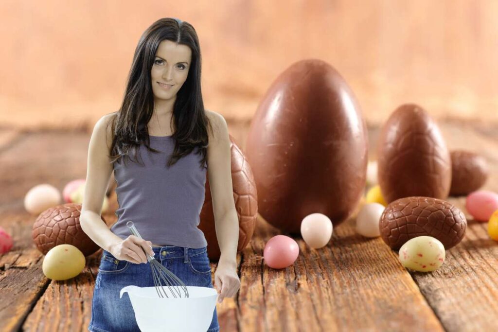 Donna con frusta da cucina e uova di cioccolato