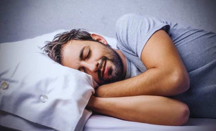 ragazzo che dorme con le mani sotto al cuscino
