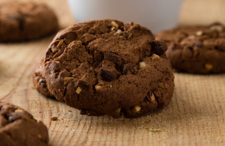 biscotti al cacao con gocce di cioccolato e pezzetti di frutta secca sopra ad un tavolo