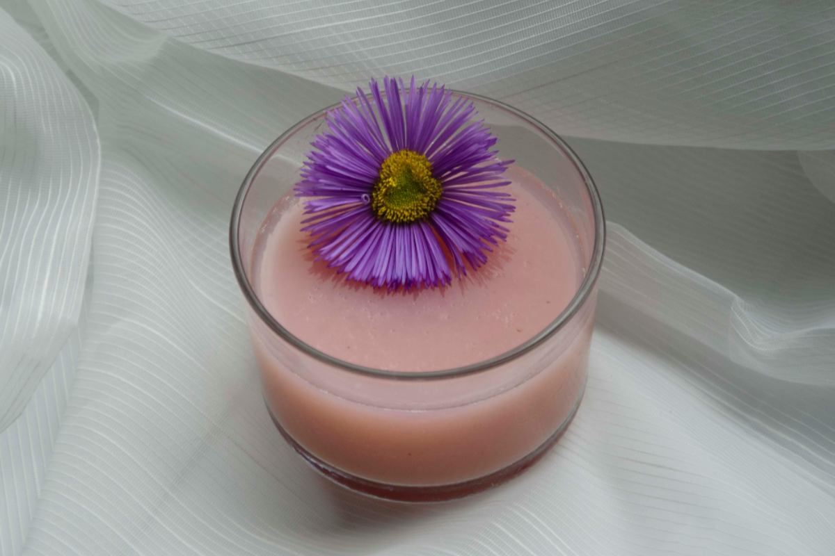 budino dentro un bicchiere di vetro con sopra un fiore viola