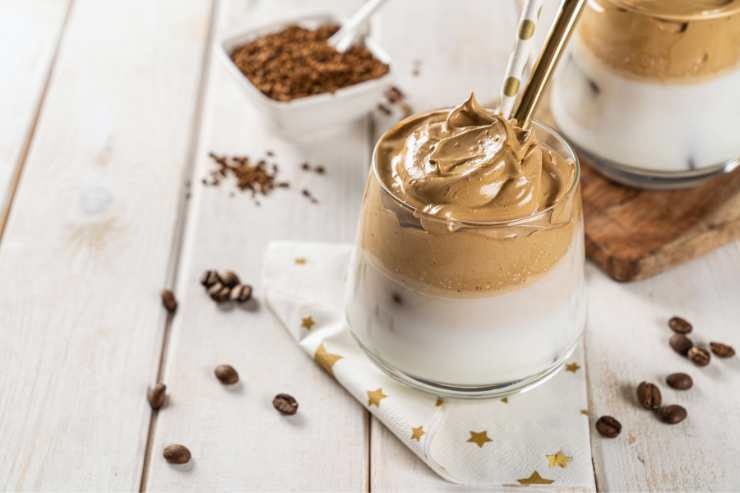 bicchiere con crema di caffè e chicchi di caffè