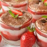 coppette di tiramisù alle fragole con accanto delle fragole fresche