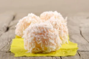 tre dolcetti ricoperti dal cocco sopra un tovagliolo giallo