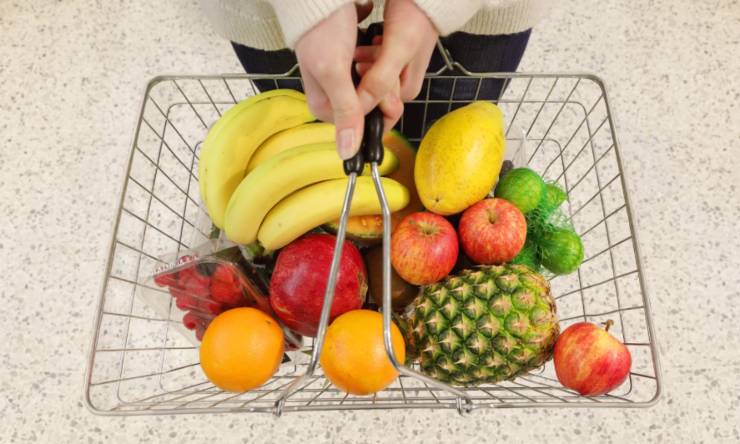 donna con in mano un cestino pieno di frutta
