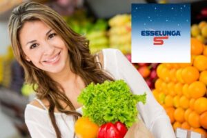 donna che sorride con in mano un sacchetto pieno di ortaggi