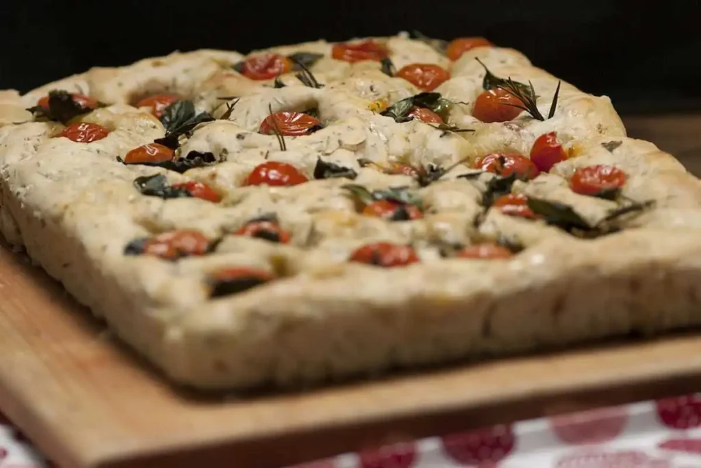 focaccia con pomodorini sopra ad un tagliere di legno