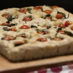 focaccia con pomodorini sopra ad un tagliere di legno