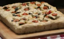 focaccia con pomodorini sopra ad un tagliere di legno