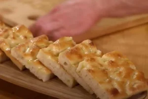 focaccia su tagliere e dietro delle mani