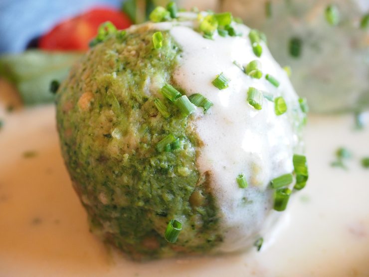 uno gnocco di spinaci condito con salsa bianca ed erba cipollina
