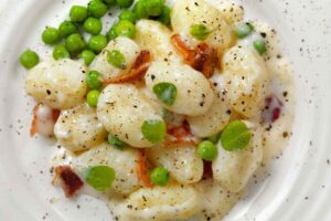 piatto di gnocchi con piselli e guanciale