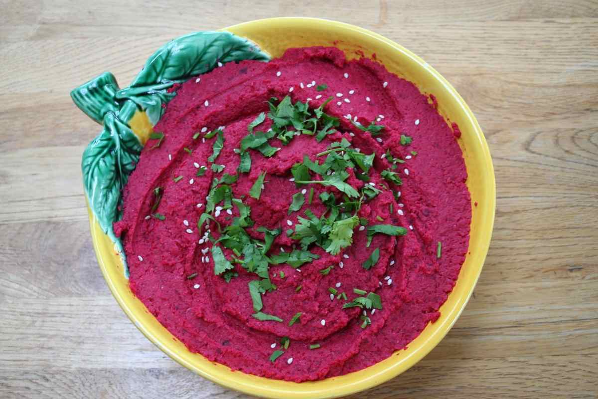 ciotola piena di hummus di barbabietola con sopra del prezzemolo