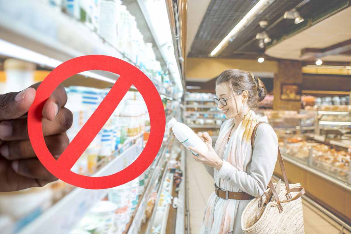 ragazza con latte nel supermercato e divieto