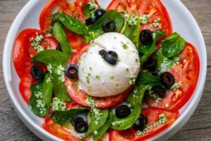 piatto con mozzarella, basilico e olive nere