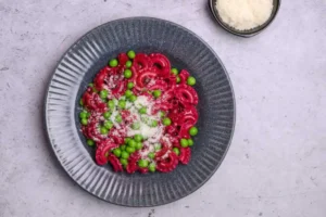 pasta con pesto alla barbabietola piselli freschi e formaggio grattugiato