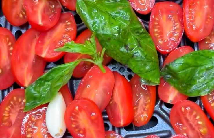 pomodorini tagliati conditi con aglio e basilico