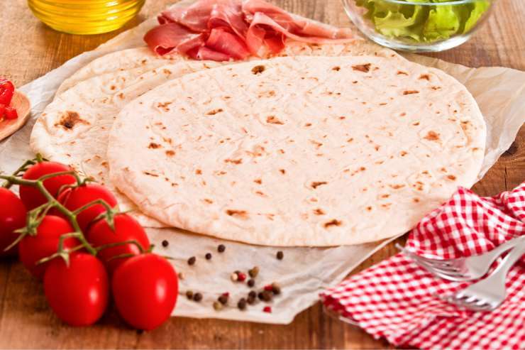 piadina sul tavolo con pomodori e prosciutto