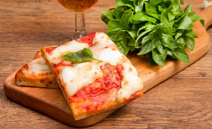 Fette quadrate di pizza con mozzarella e sugo
