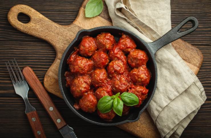 polpette al sugo in padella e accanto forchetta e coltello