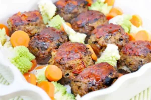 polpette di melanzane dentro ad una teglia insieme a broccoli e carote