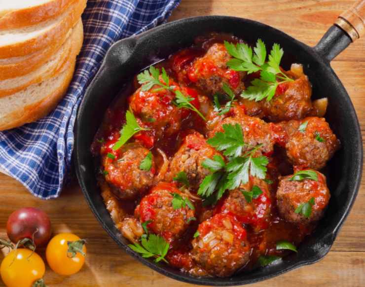 polpette al sugo in padella con sopra del prezzemolo