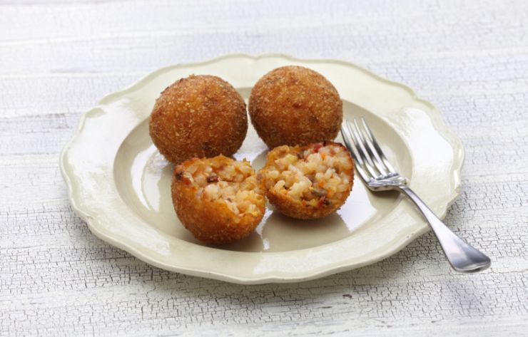 polpette di riso su un piatto bianco con accanto una forchetta