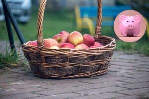 cesto di mele e salvadanaio a forma di maialino rosa