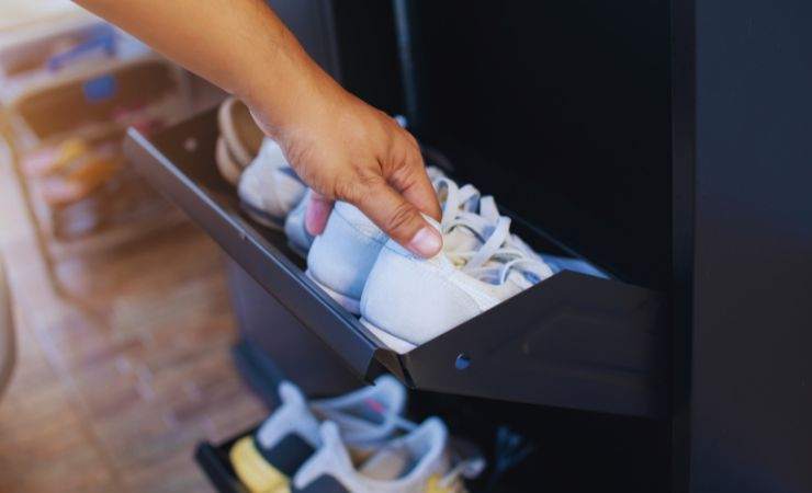 mano prende scarpe dalla scarpiera