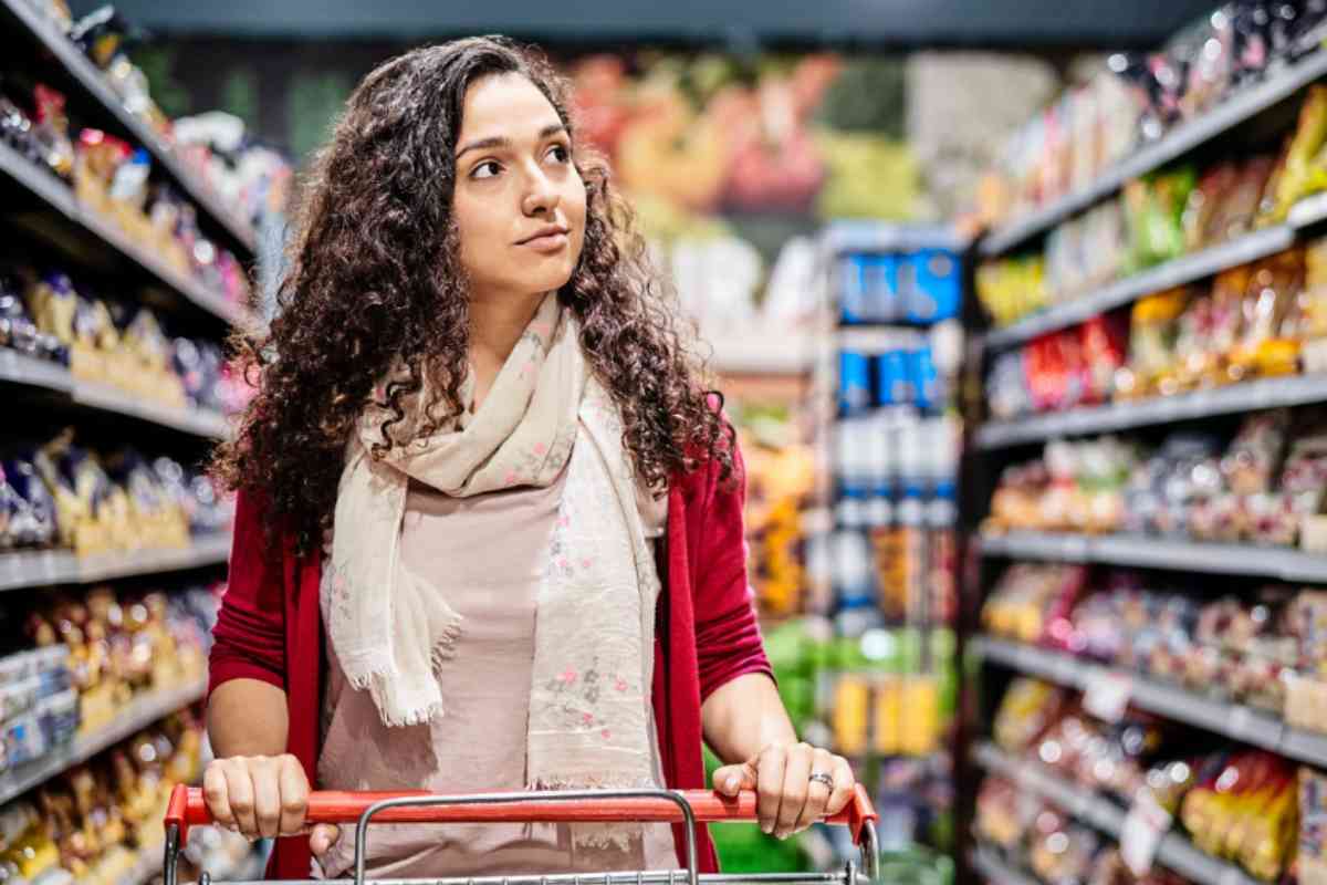 Donna al supermercato con carrello
