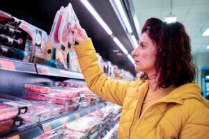 Donna che prende confezione di carne