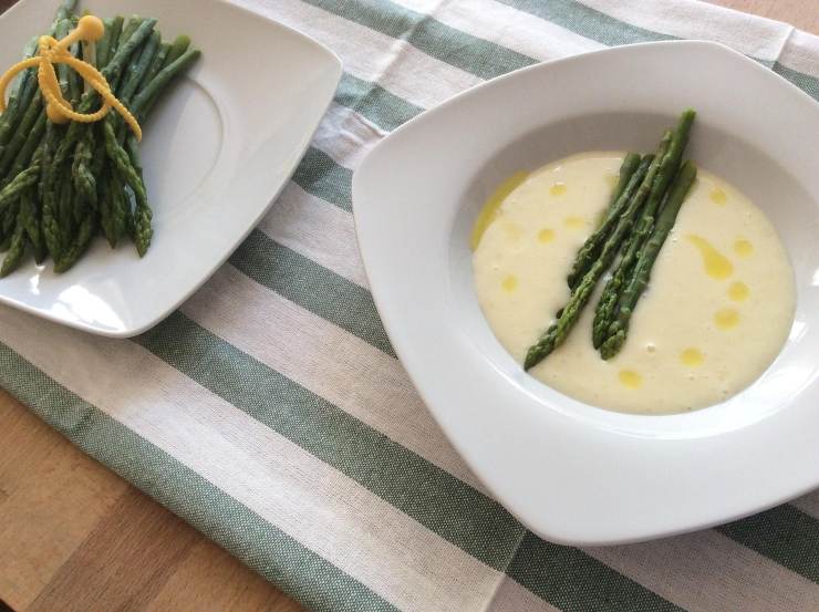 piatto con dentro una vellutata e sopra degli asparagi