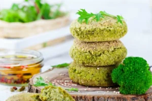 tre burger di broccoli uno sopra all'altro sopra ad un tagliere