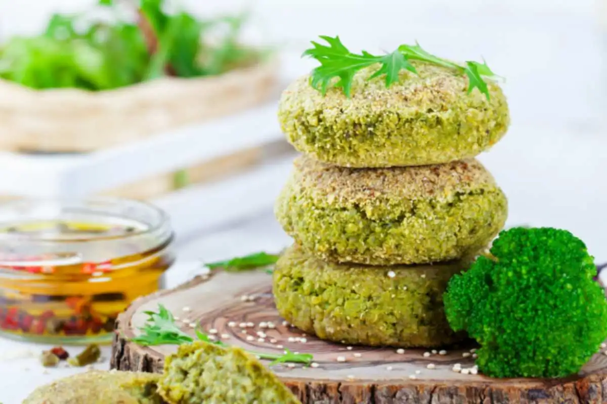 tre burger di broccoli uno sopra all'altro sopra ad un tagliere