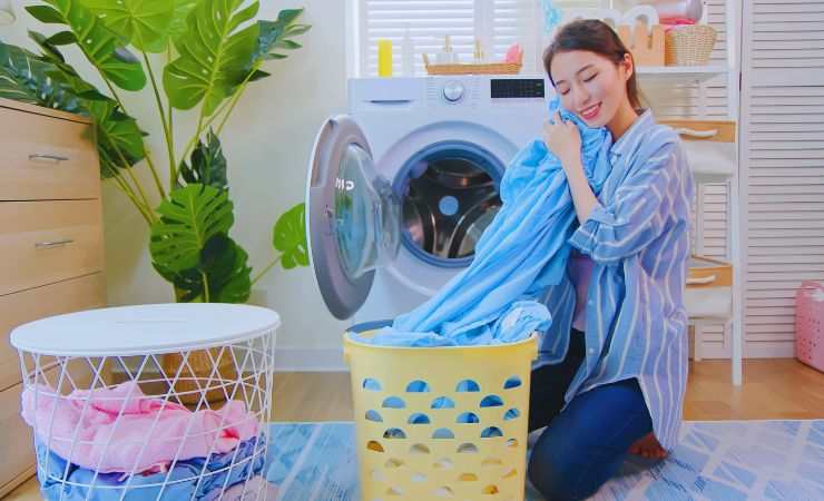 ragazza tira fuori vestiti dalla lavatrice