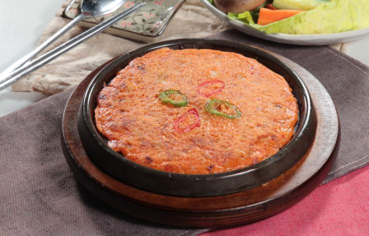 frittata di riso al pomodoro dentro alla teglia con sopra dei peperoni a rondelle
