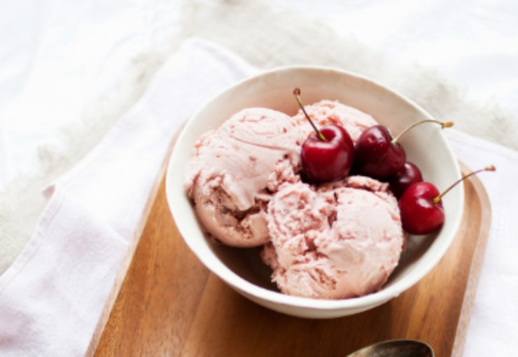 gelato dentro ad una tazza con sopra delle ciliegie
