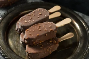 gelati su stecco ricoperti di cioccolato sopra ad un vassoio