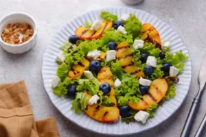 insalatona con pesche tofu e mirtilli dentro ad un piatto