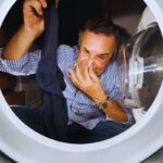 uomo annusa calzino fuori lavatrice