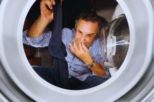 uomo annusa calzino fuori lavatrice
