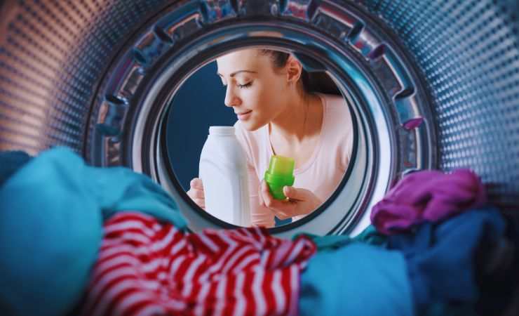 ragazza respira odore sapone fuori dalla lavatrice