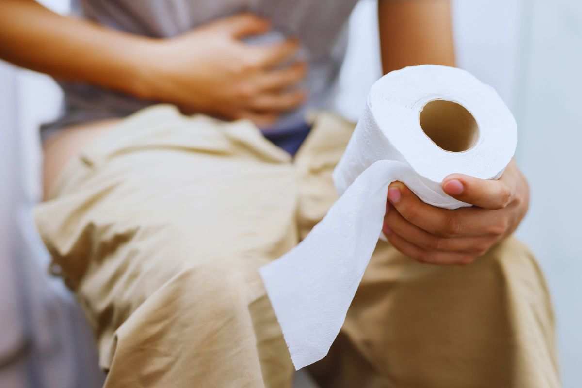 persona al bagno con carta igienica in mano