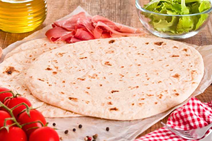 piadine sul tagliere con pomodori, olio e insalata