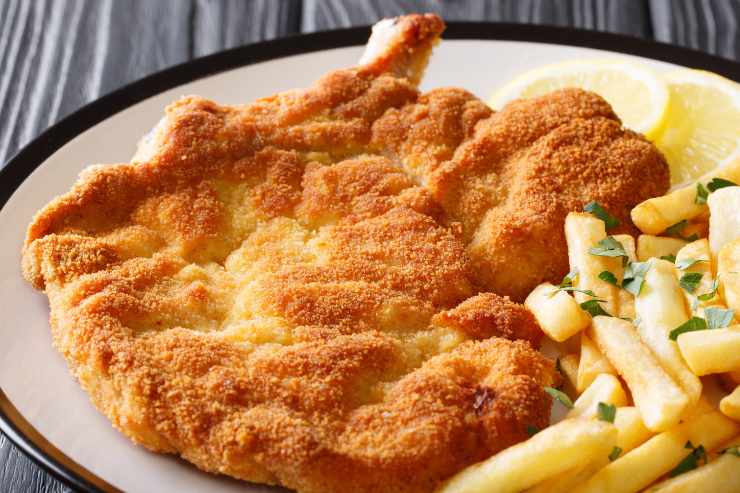 piatto con cotoletta alla milanese e patatine fritte