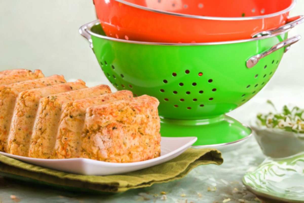 polpettone di zucchine e carote sopra ad un piatto, accanto degli scolapasta