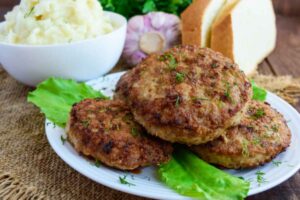 tre burger su un piatto con sotto delle foglie di insalata