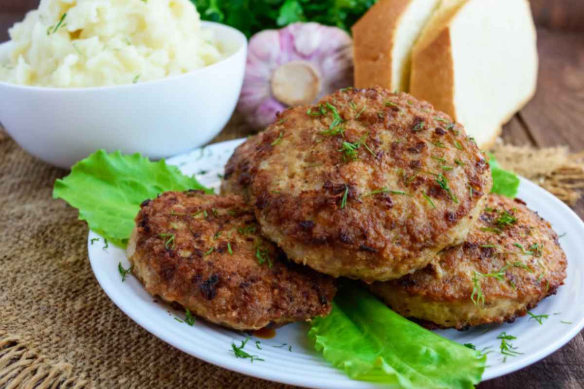 tre burger su un piatto con sotto delle foglie di insalata