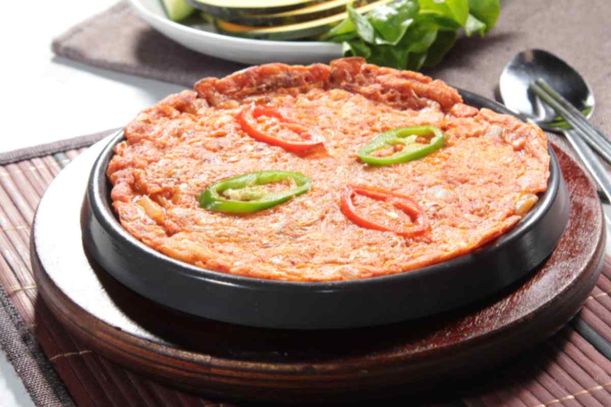 frittata di riso al pomodoro con sopra dei peperoni tagliati a rondelle