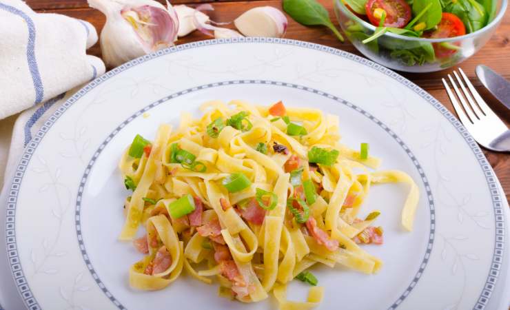 piatto di tagliatelle con cipollotto e pancetta